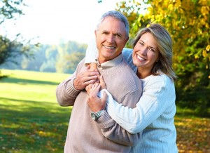 Middle-aged couple smiling with their arms around each other outdoors