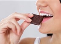 Young woman eating a bar of chocolate
