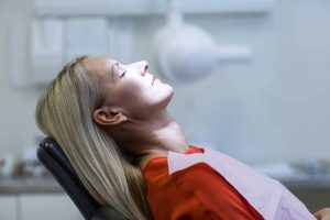 middle-aged female patient relaxing in the dental chair