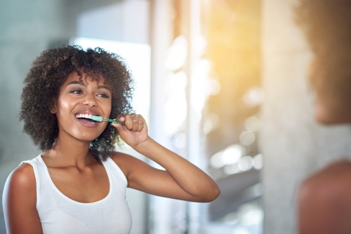 black woman brushing teeth