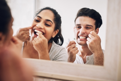 couple flossing in mirror